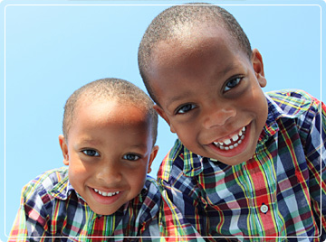 photo of two boys leaning over camera